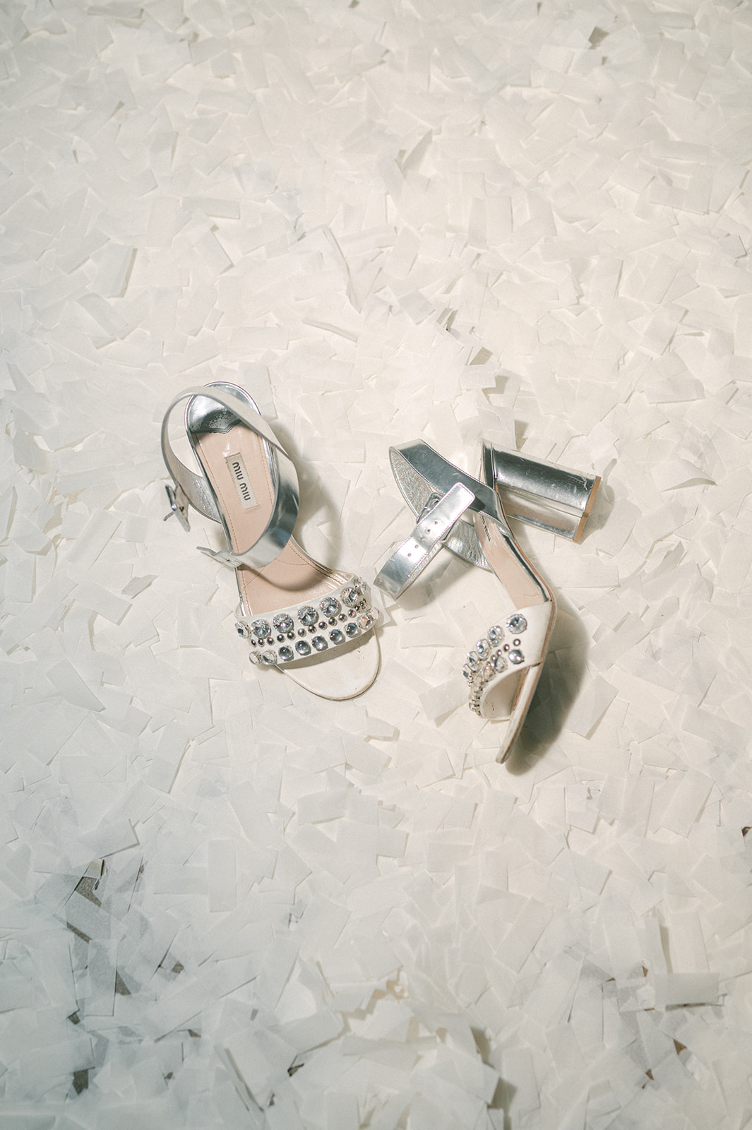 Bride's shoes in confetti during dance party.
