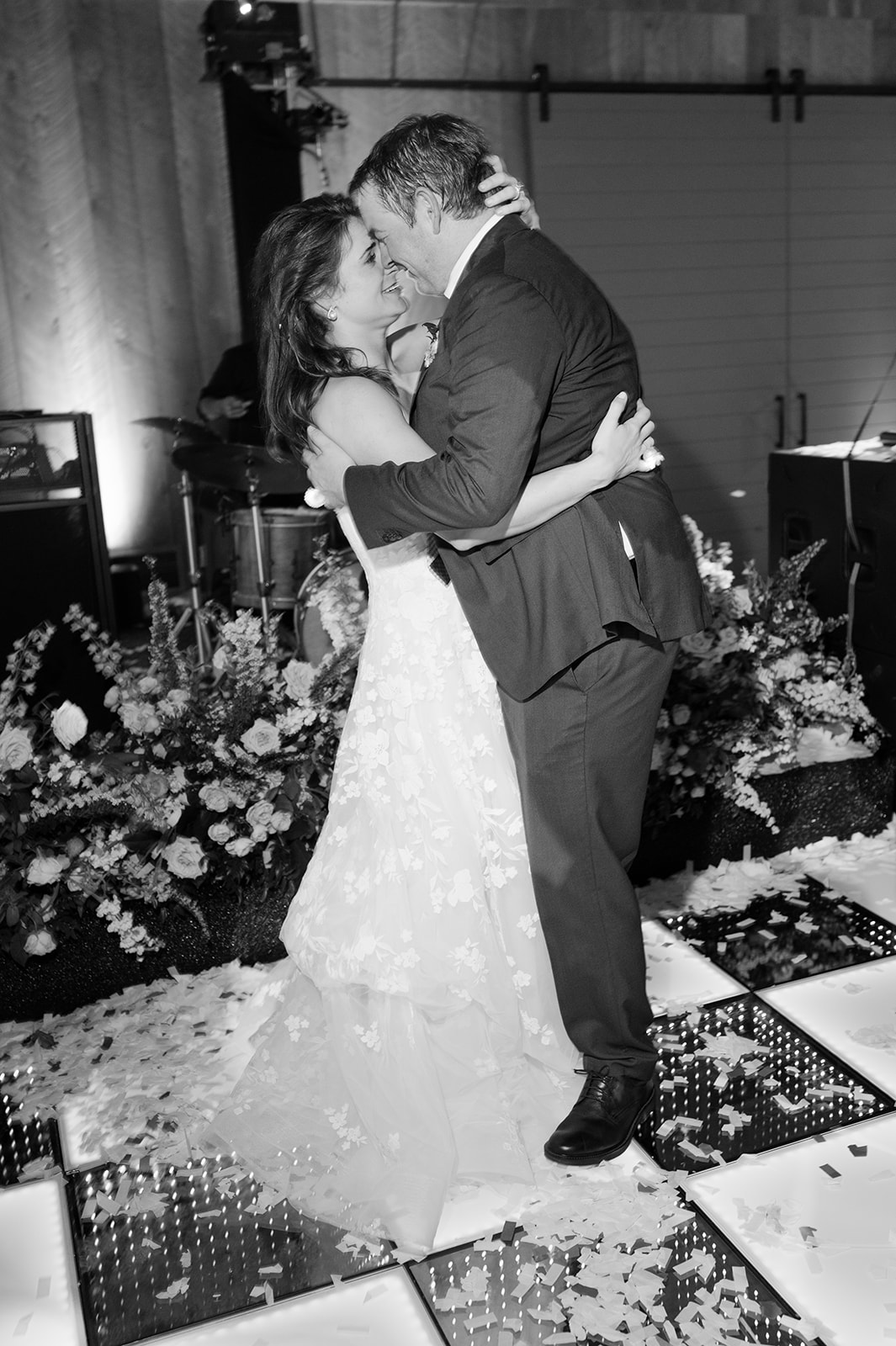 Bride and groom dancing under the lights at outdoor vineyard wedding.