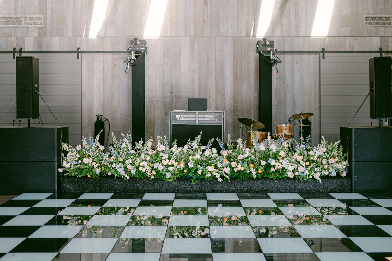 Checkered dance floor and floral band setup at a vineyard wedding in Napa.