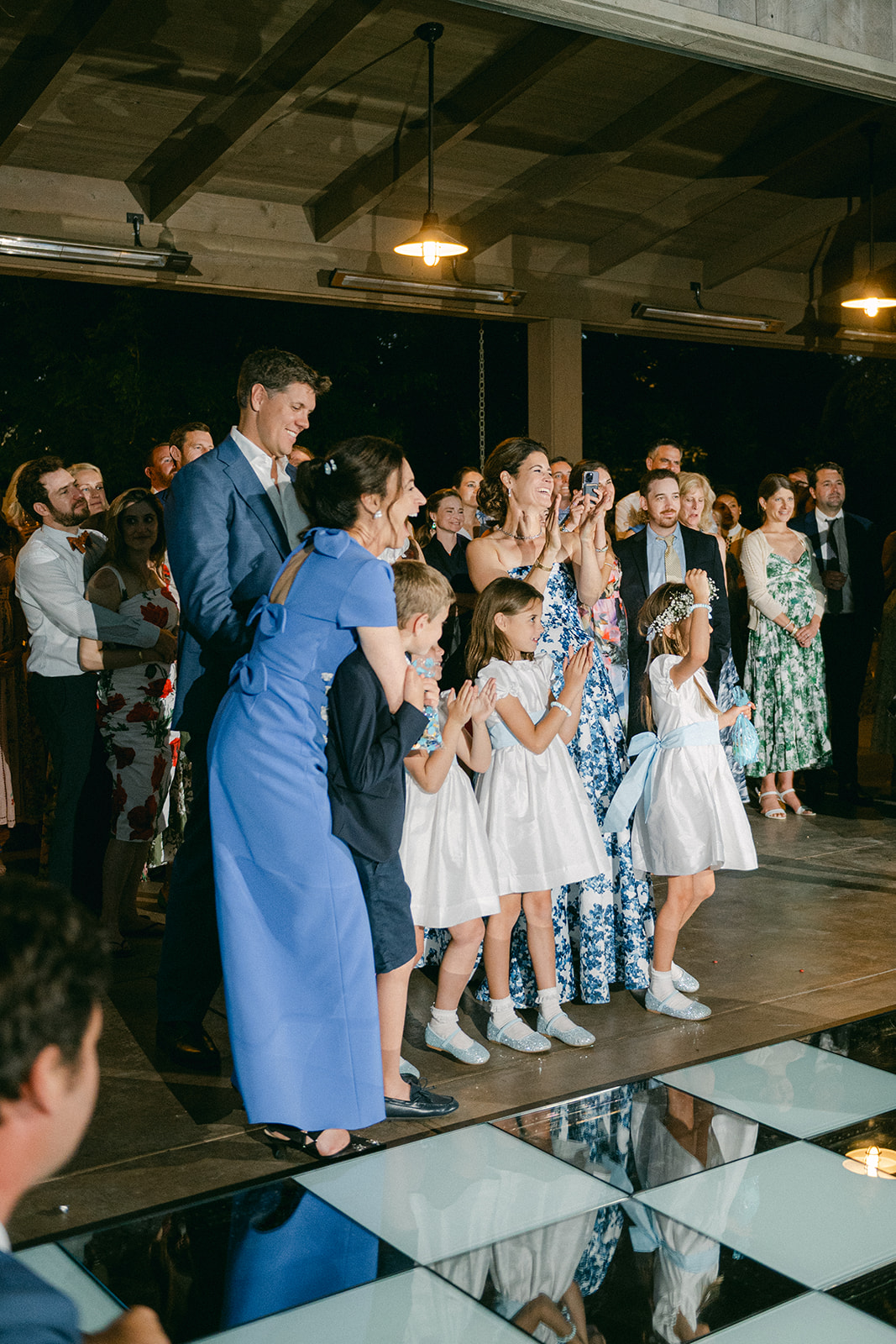 Guests clapping during parent dances. 