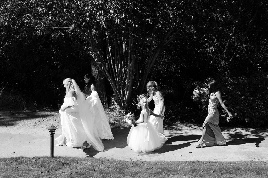Candid moment of bride and bridesmaids walking before portraits.