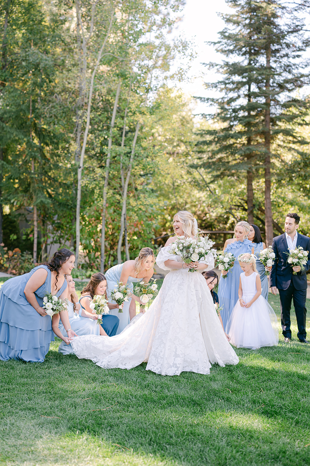 Bridal party fixing the bride's gown during portraits.