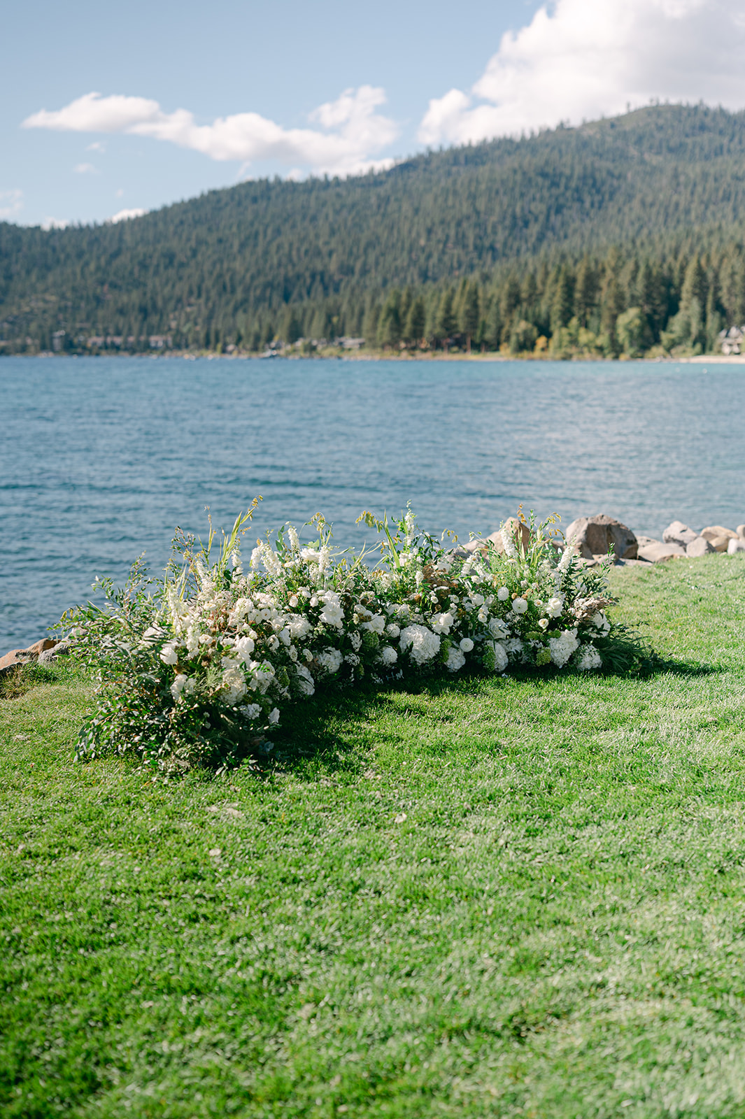 Grounded floral arch framing the lake view at the altar of a North Lake Tahoe wedding.