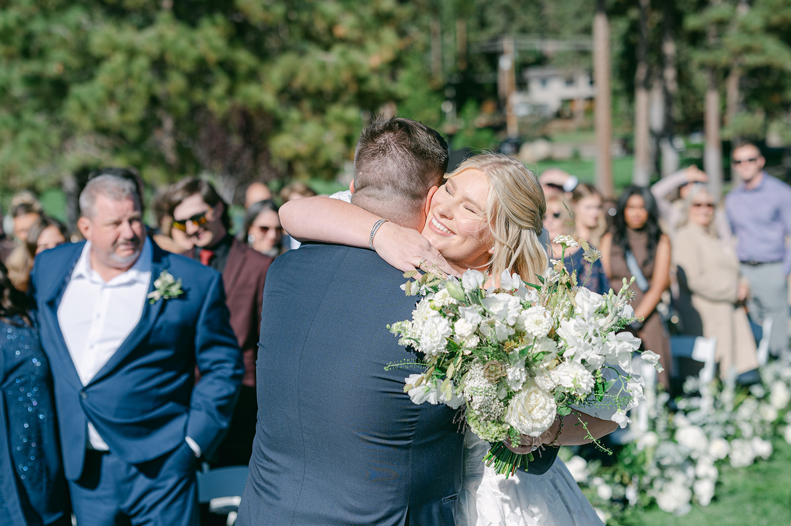 Bride hugging the groom at the altar after walking down the aisle.