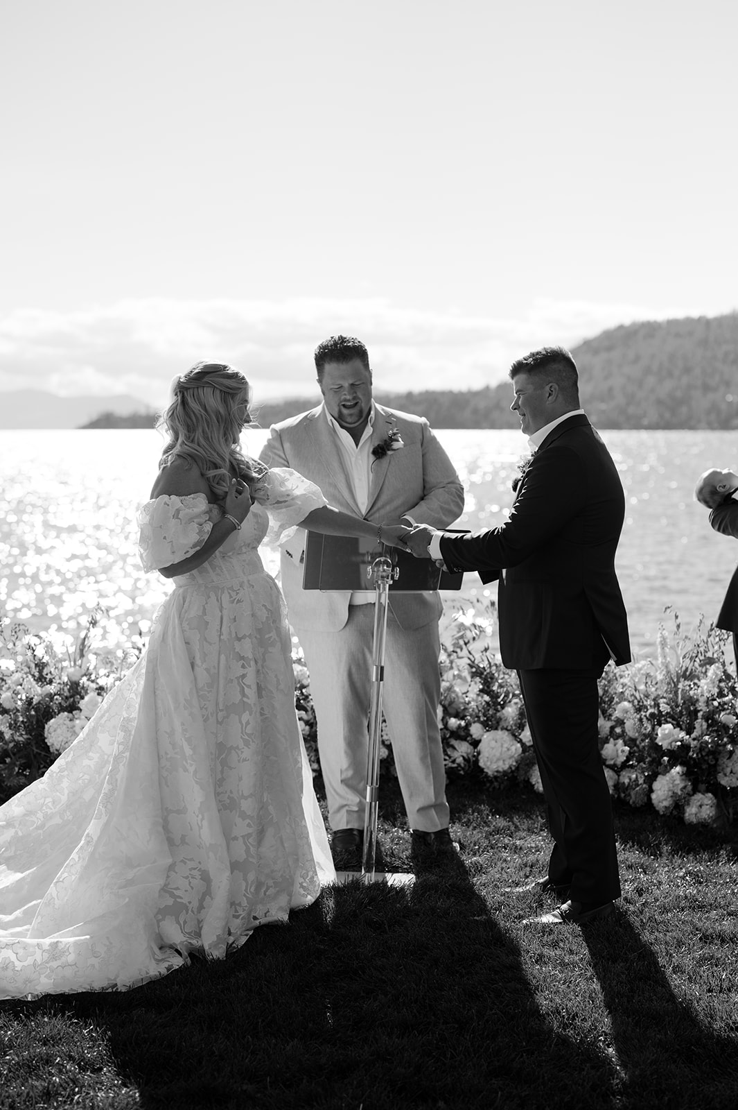 Black and white shot of the couple holding hands during their North Lake Tahoe lakeside ceremony.