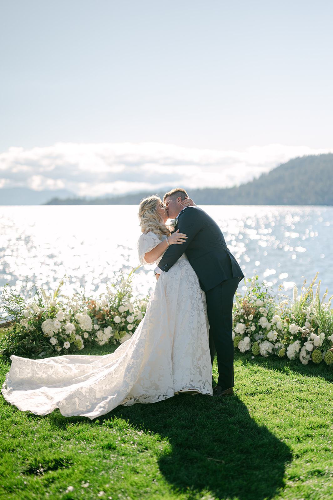 Bride and groom ceremony kiss at the altar with Lake Tahoe in the background.