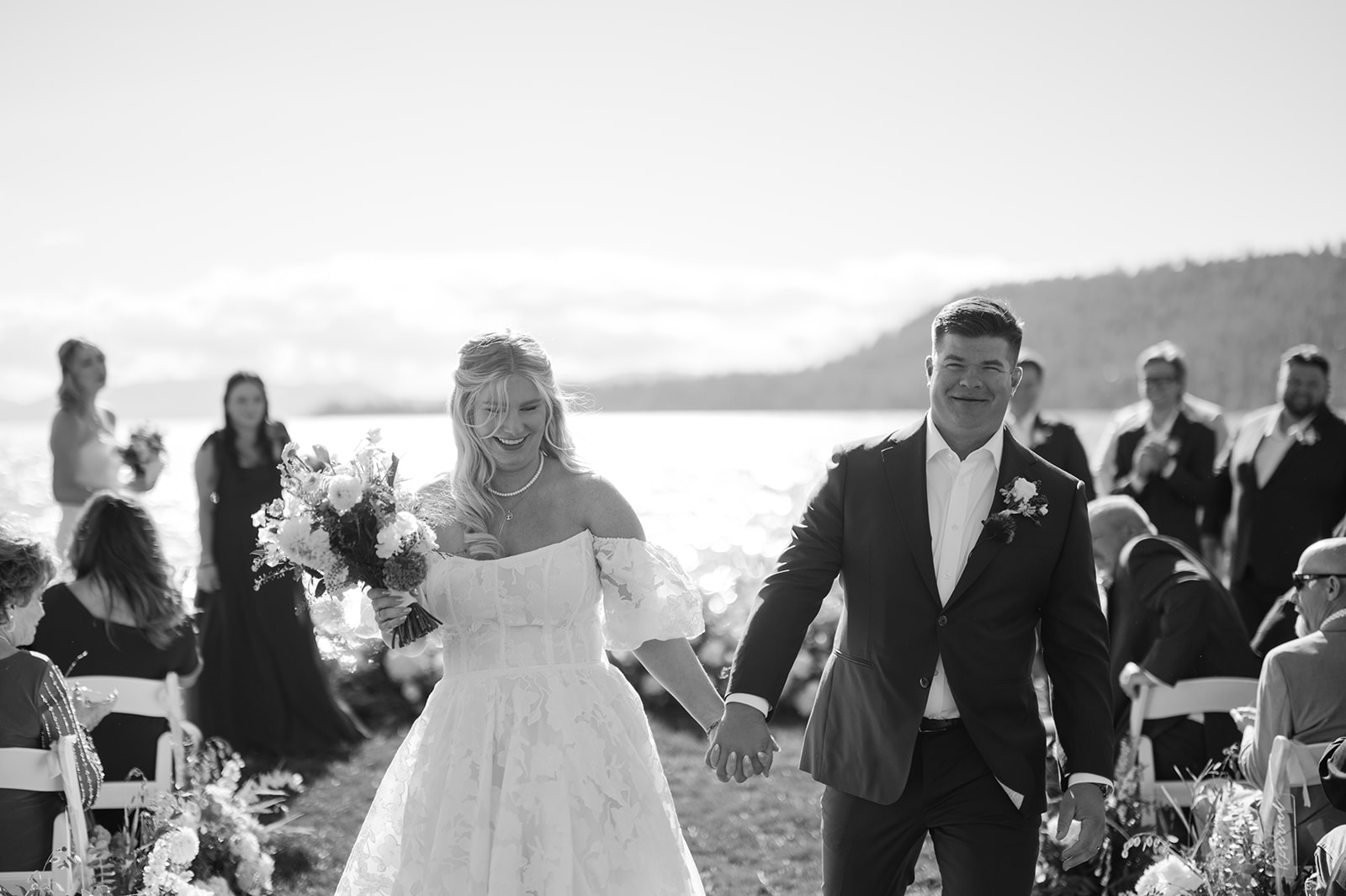 Bride and groom walking down the aisle together holding hands and smiling.