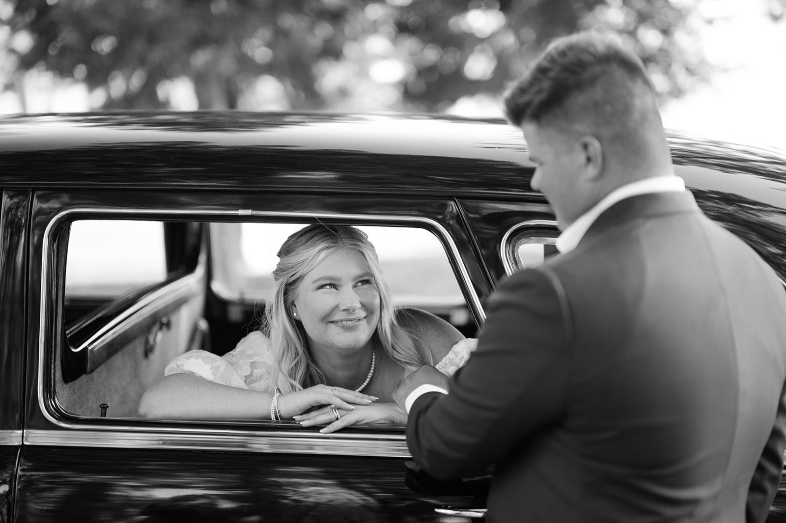 Bride and groom portraits inside a vintage Packard car.