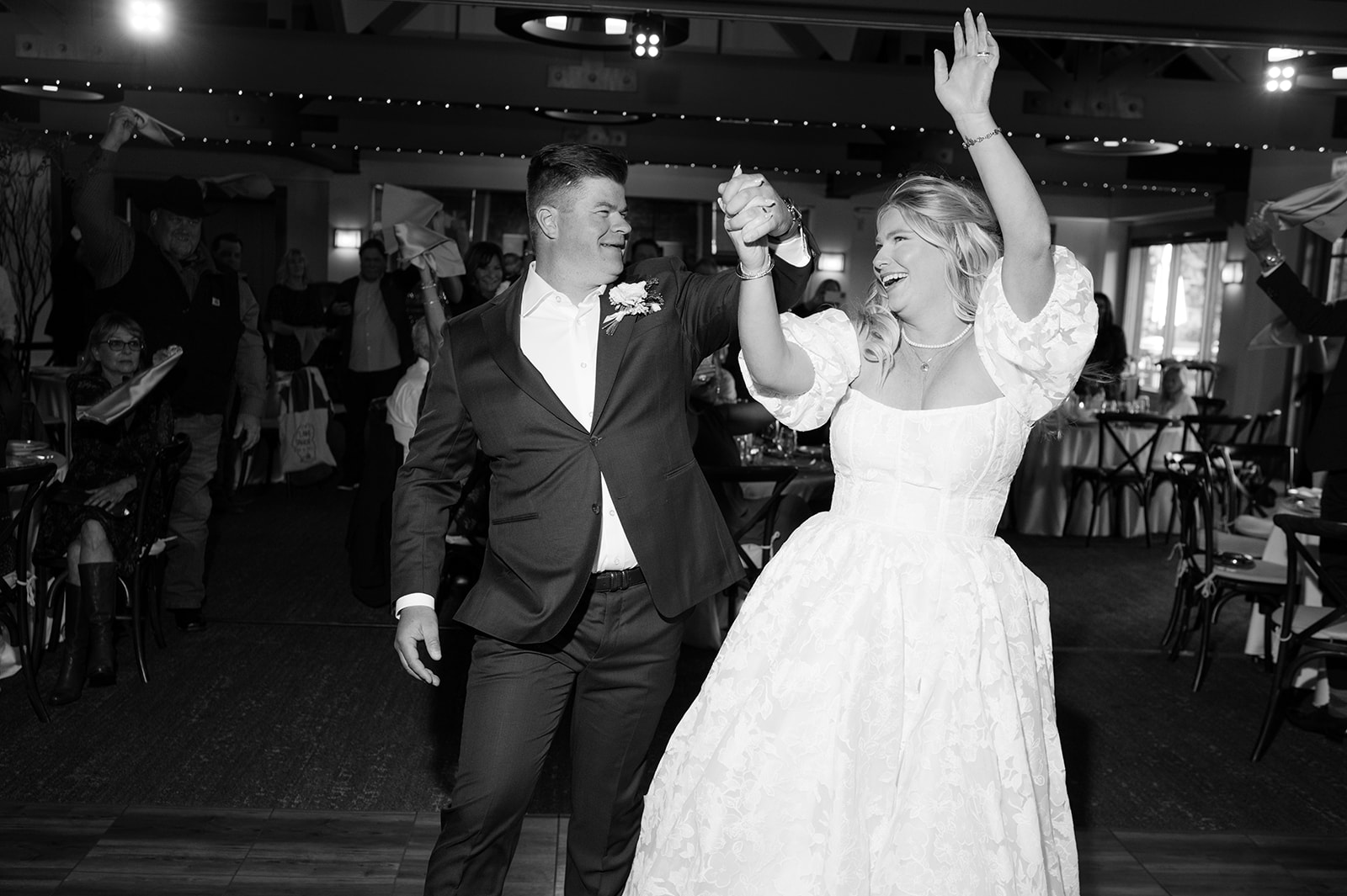 Bride and groom candid wedding reception entrance.