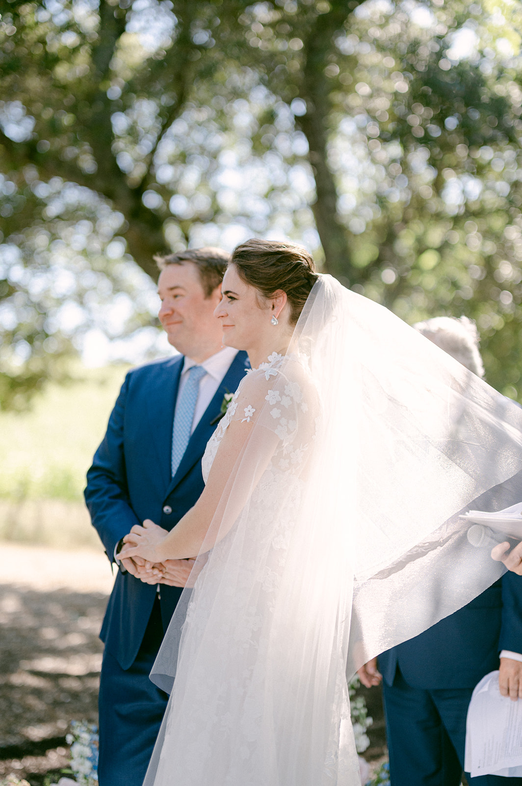 Emotional wedding ceremony moment when bride and groom look towards their guests.