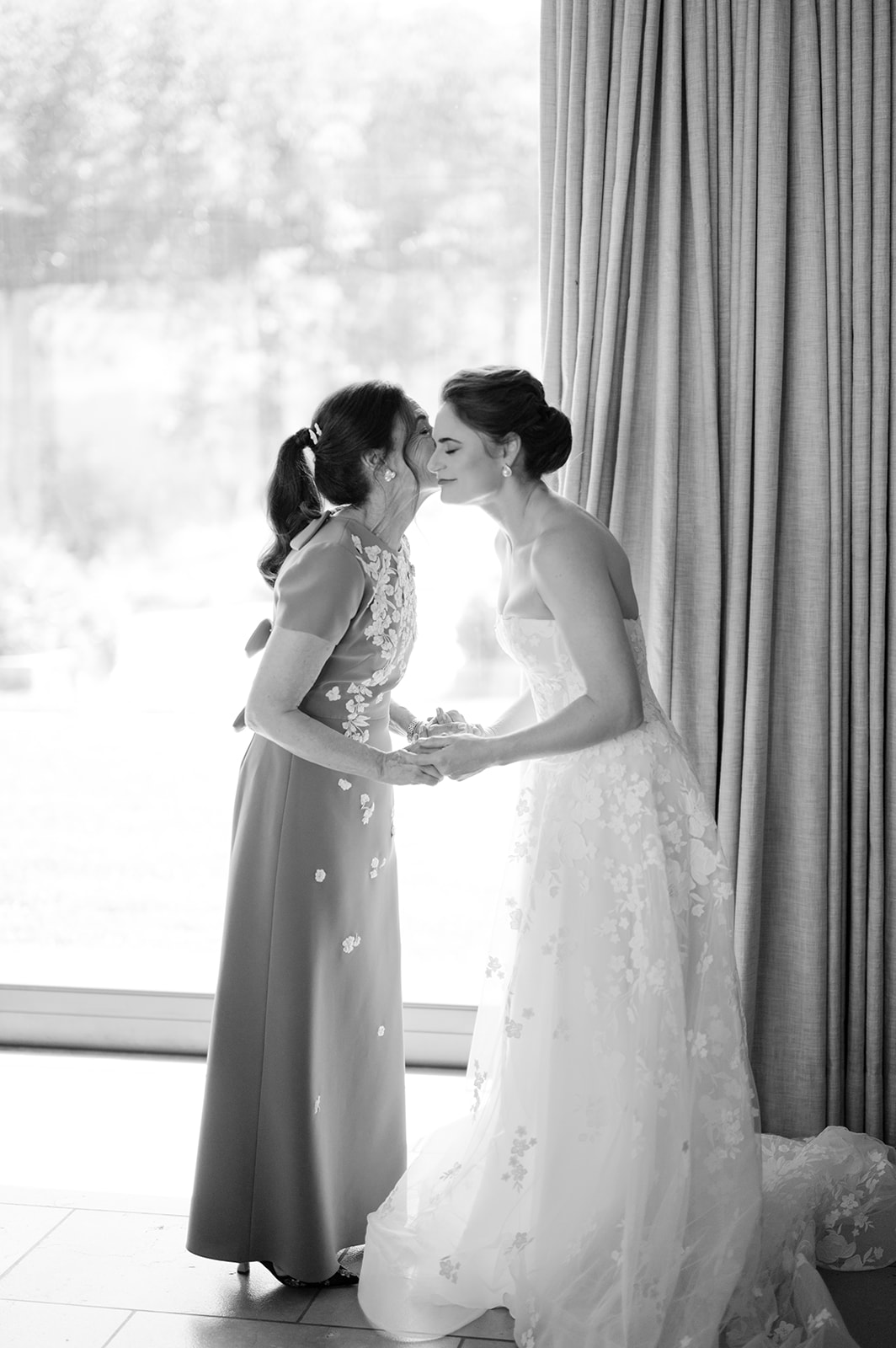 Candid photograph of bride and her mom while getting ready for the wedding ceremony.
