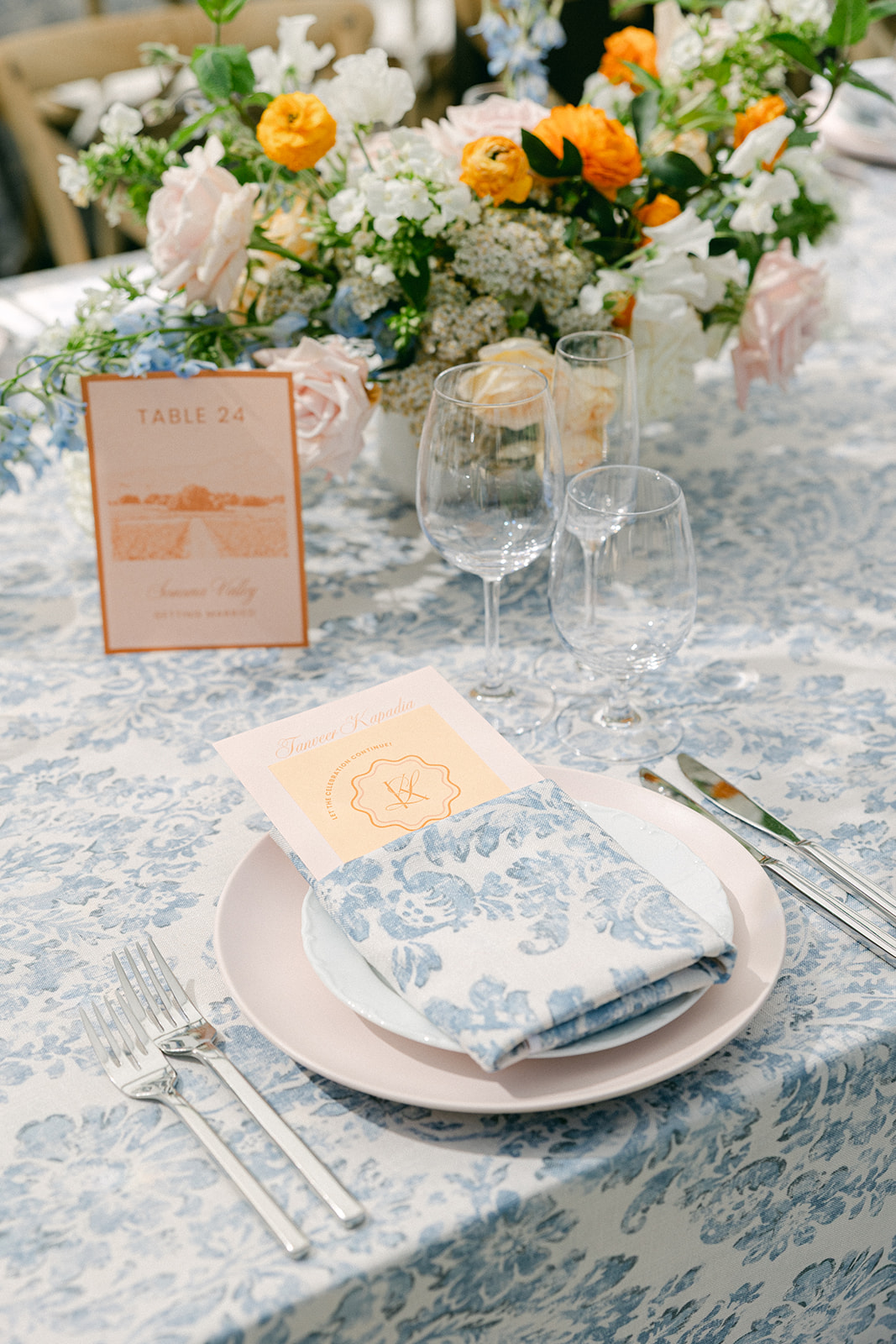 Reception place settings with blue floral linens and handwritten notes from the couple.