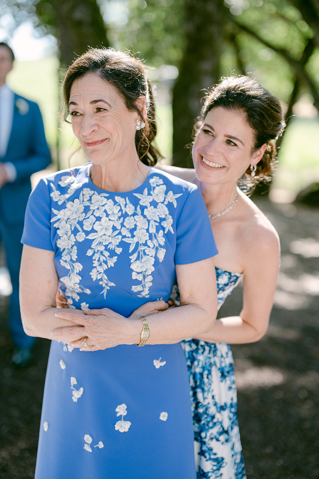 Candid moment of bride's sister and mother watching wedding ceremony.