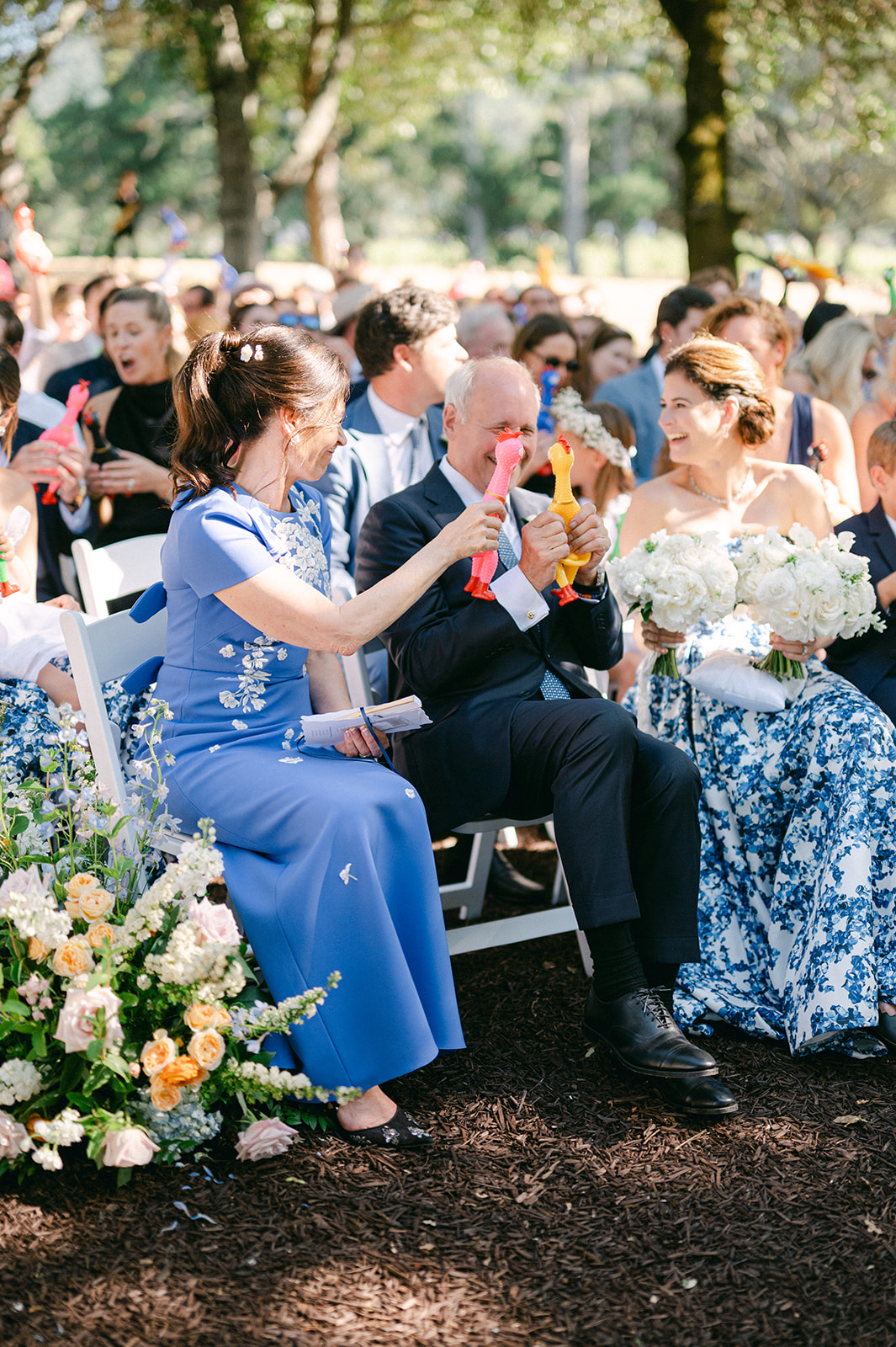 Bride's parents holding rubber chickens during ceremony.